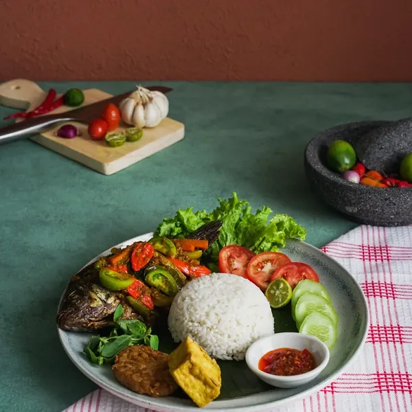 Nila Pesmol, whole tilapia in a turmeric sauce with tomato, served with rice.