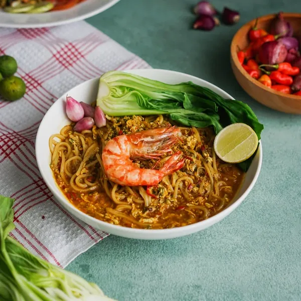 Mie Aceh, thick noodles in a dark spiced curry topped with a prawn.