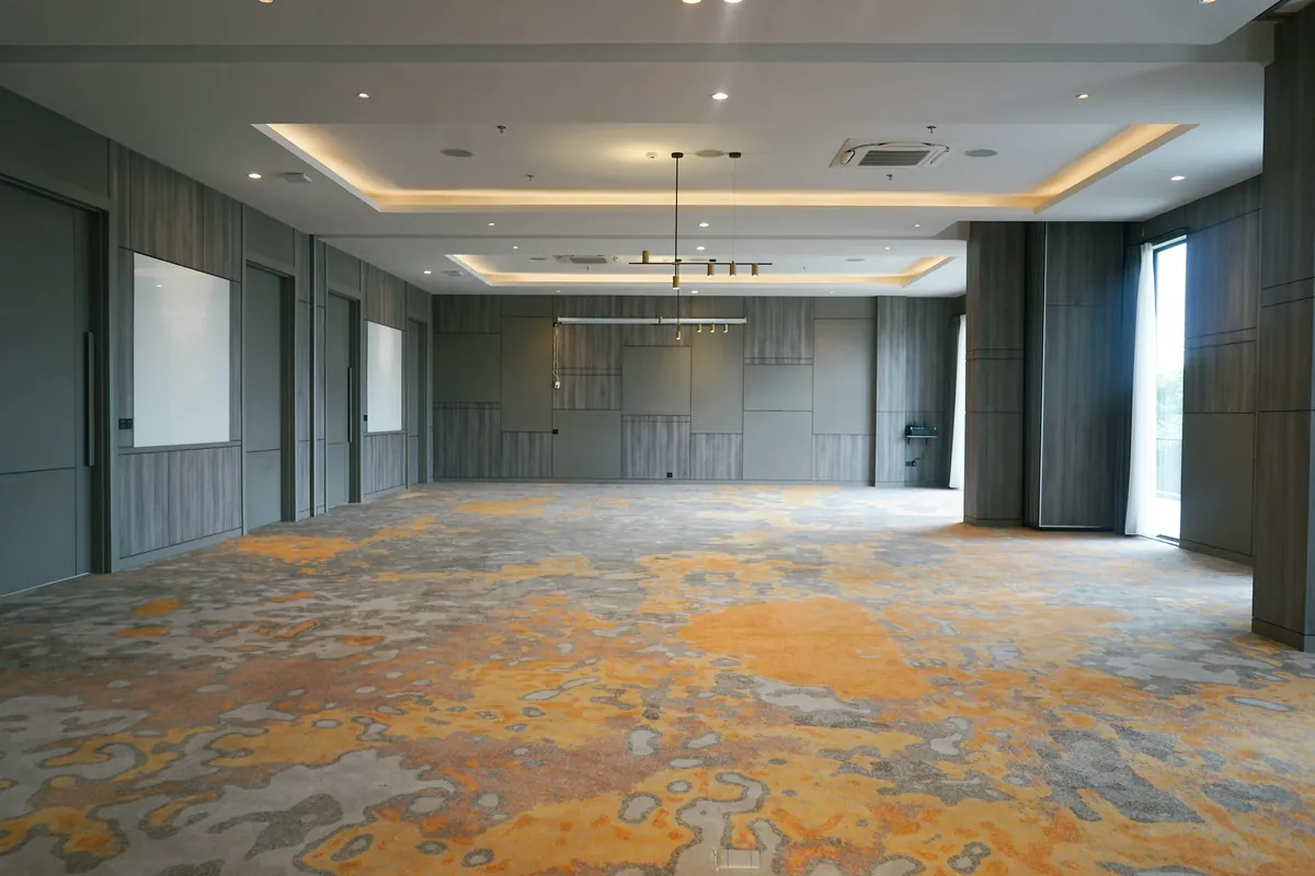 The ballroom empty and column-free, daylight from the terrace doors at the far end.