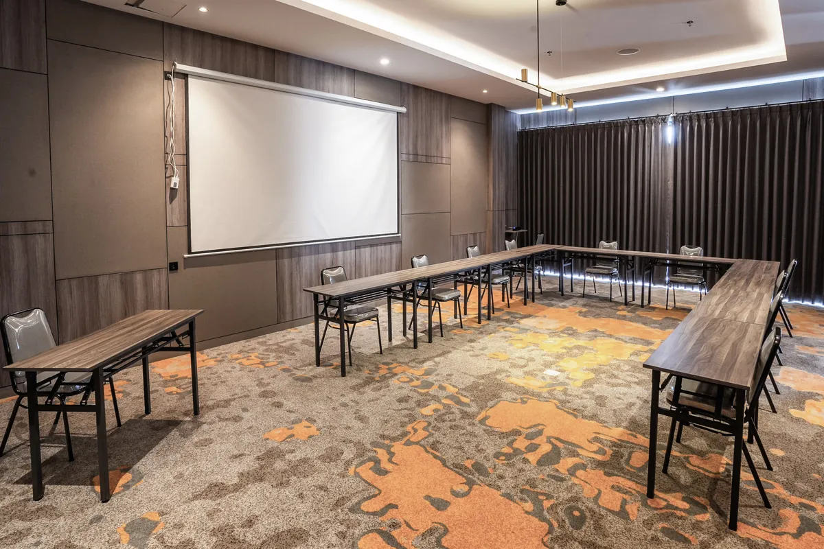 A meeting room in a U-shape facing the projector screen.