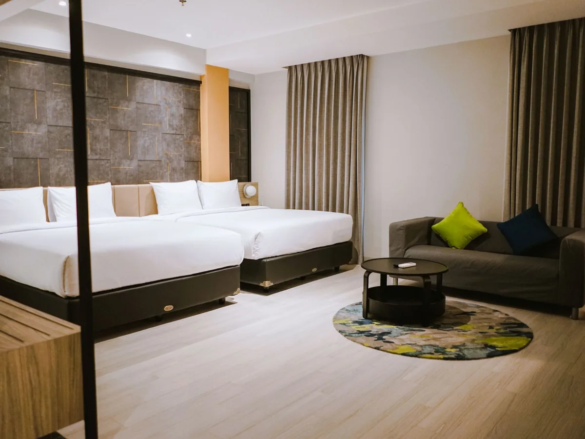 A Family Suite with two king beds and a separate sofa and coffee table by the window.